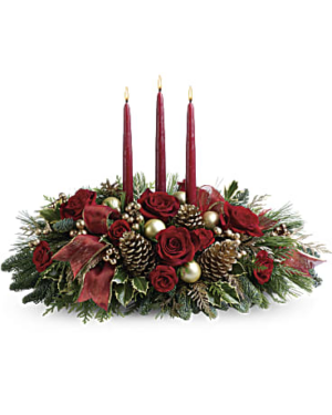 A centerpiece arrangement with holly, noble fir, white pine, flat cedar, and spray roses is decorated with golden berries, Christmas ornaments, pinecones and three red taper candles